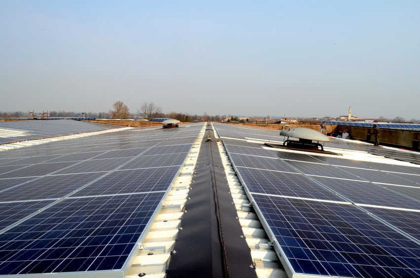Installazione di pannelli fotovoltaici su un tetto di un capannone industriali.